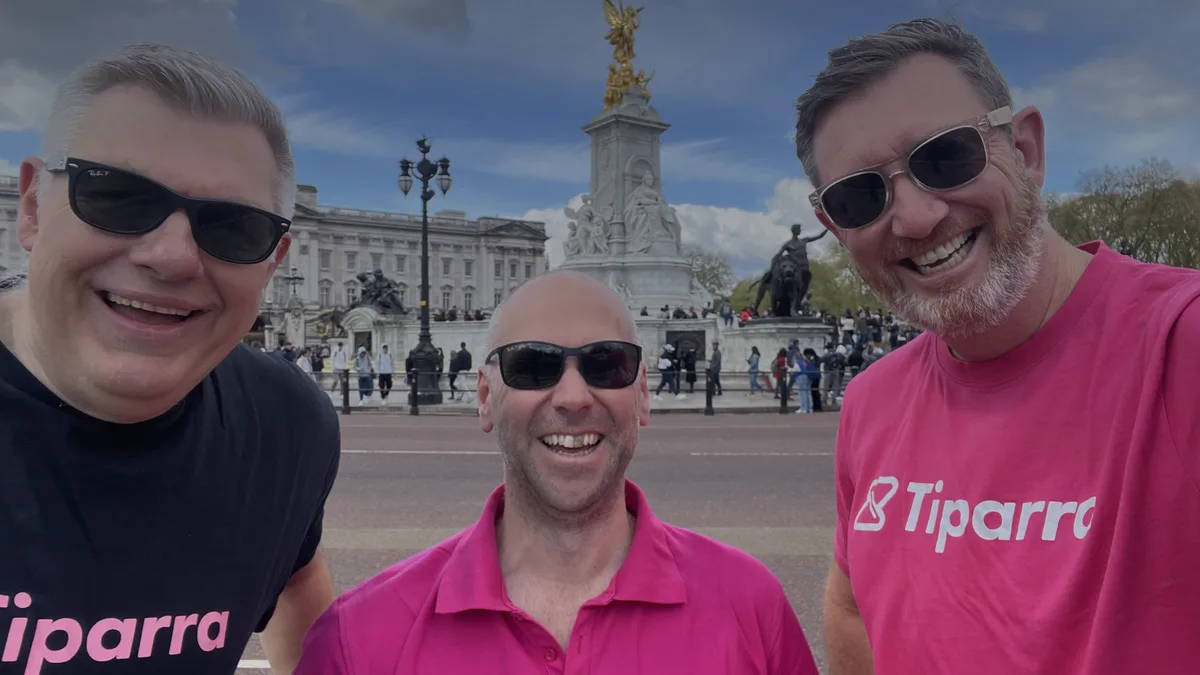 Happy students on a modern campus plaza showing digital connectivity and a sense of belonging.