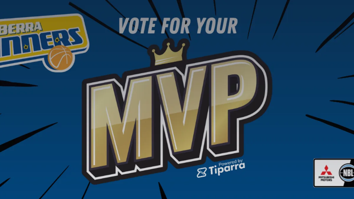 Fan holding a smartphone at a stadium displaying a sponsor-branded redeem now offer button.